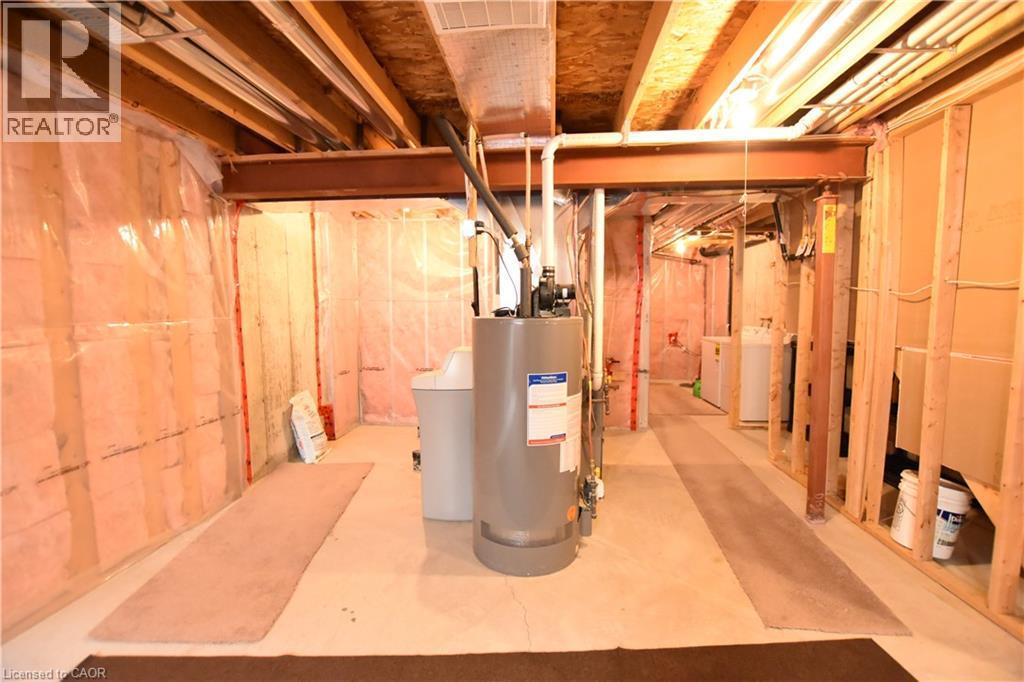 Unfinished below grade area featuring water heater, a water softener, and washing machine and dryer - 52 Meadowridge Street, Kitchener, ON - Indoor Photo Showing Basement