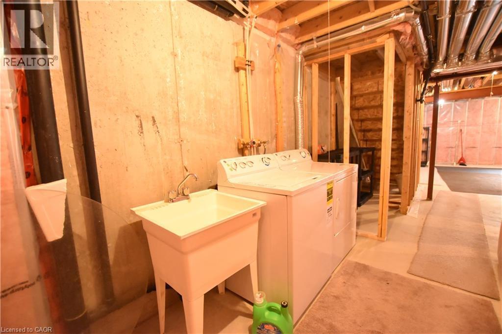 Laundry area featuring concrete floors and washer and clothes dryer - 52 Meadowridge Street, Kitchener, ON - Indoor Photo Showing Laundry Room