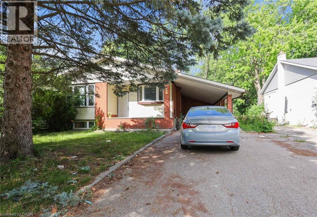 View of front of property featuring driveway, an attached carport, brick siding, and a front yard - 7 Cardill Crescent, Waterloo, ON - Outdoor