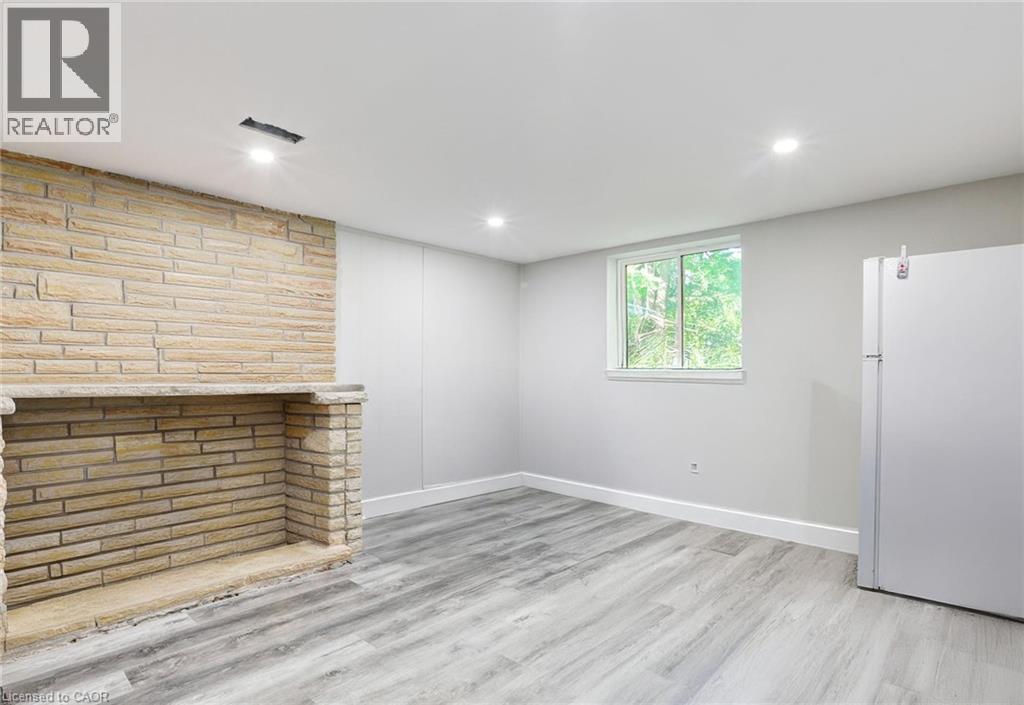Below grade area with freestanding refrigerator, light wood-type flooring, and recessed lighting - 7 Cardill Crescent, Waterloo, ON - Indoor Photo Showing Other Room