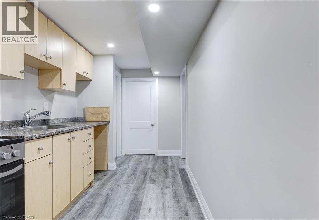Kitchen with light wood finish cabinetry, stainless steel stove, recessed lighting, and light wood-style flooring - 7 Cardill Crescent, Waterloo, ON - Indoor Photo Showing Kitchen