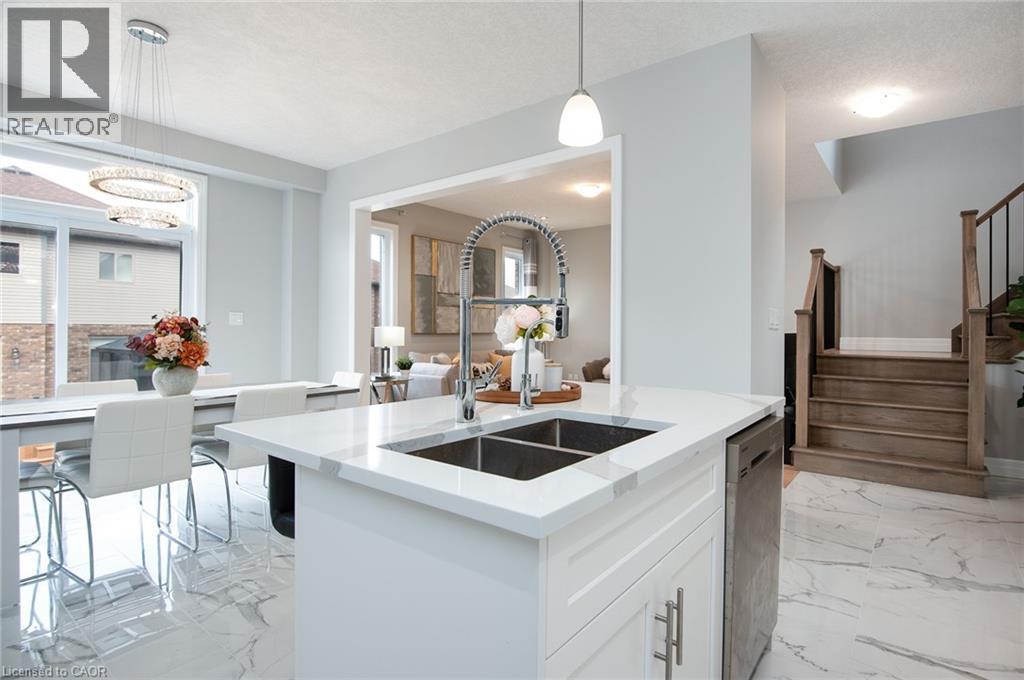 Kitchen with white cabinets, light stone counters, light marble finish flooring, an island with sink, and stainless steel dishwasher - 346 Chokecherry Crescent, Waterloo, ON - Indoor Photo Showing Kitchen With Double Sink With Upgraded Kitchen