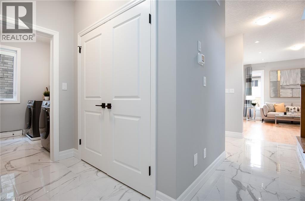 Hallway with light marble finish floors, washing machine and dryer, recessed lighting, and a textured ceiling - 346 Chokecherry Crescent, Waterloo, ON - Indoor Photo Showing Other Room