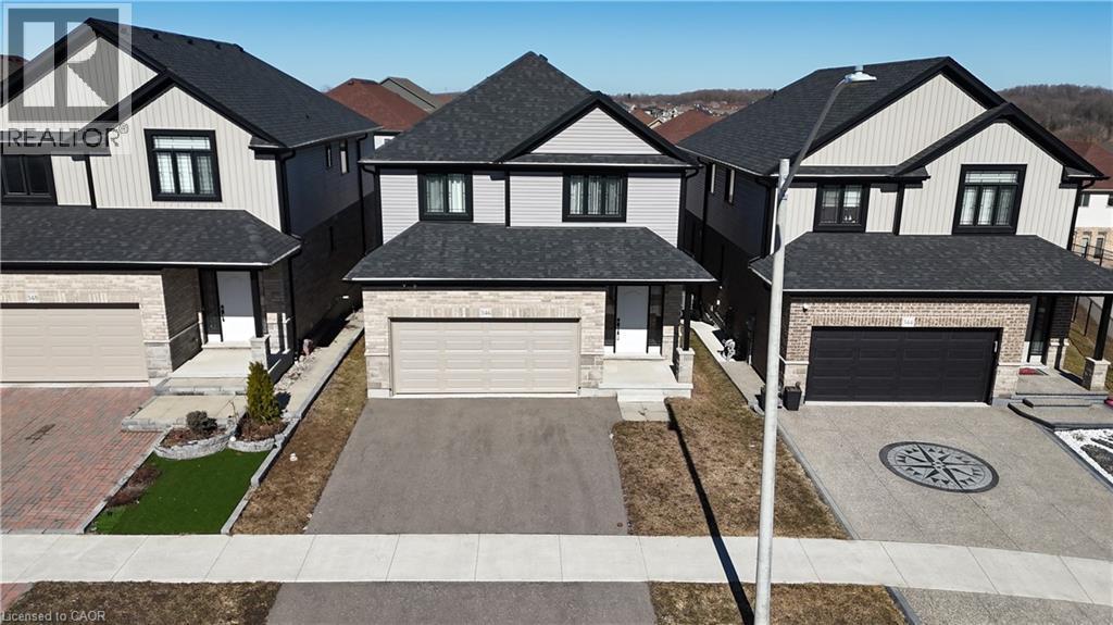 View of front of home with a shingled roof, driveway, and brick siding - 346 Chokecherry Crescent, Waterloo, ON - Outdoor With Facade