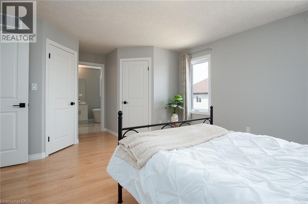 Bedroom featuring light wood-type flooring, a closet, and a textured ceiling - 346 Chokecherry Crescent, Waterloo, ON - Indoor Photo Showing Bedroom
