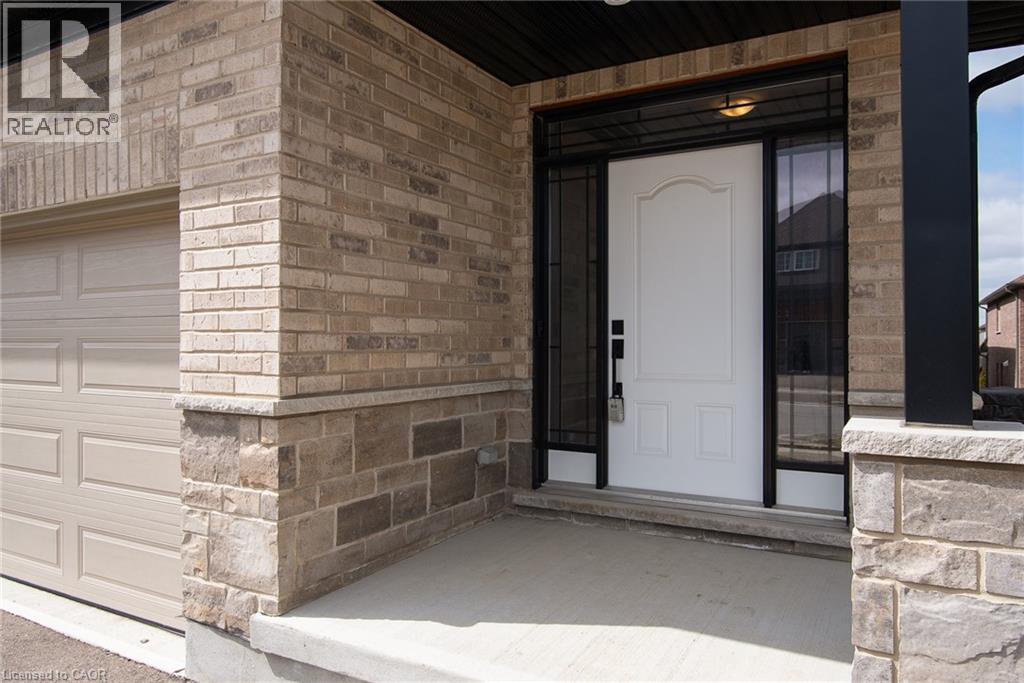 Doorway to property featuring a garage, covered porch, and brick siding - 346 Chokecherry Crescent, Waterloo, ON - Outdoor With Exterior