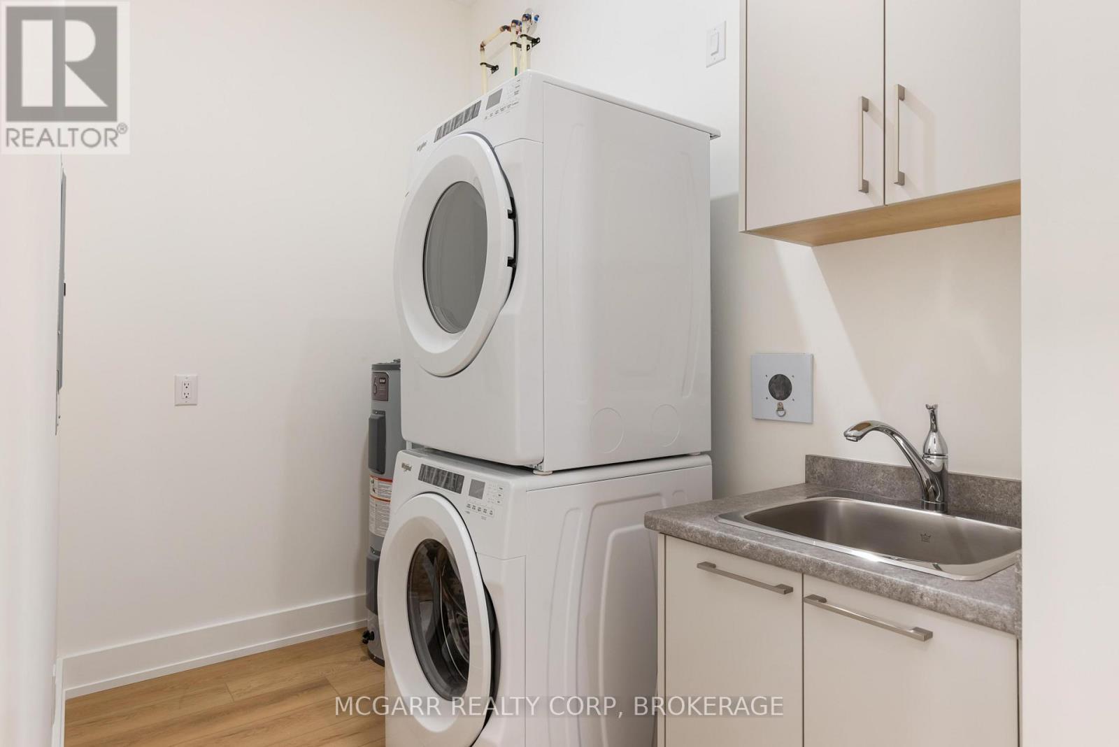 Laundry room with sink washer and dryer - 507 - 77 Yates Street, St. Catharines (Downtown), ON - Indoor Photo Showing Laundry Room