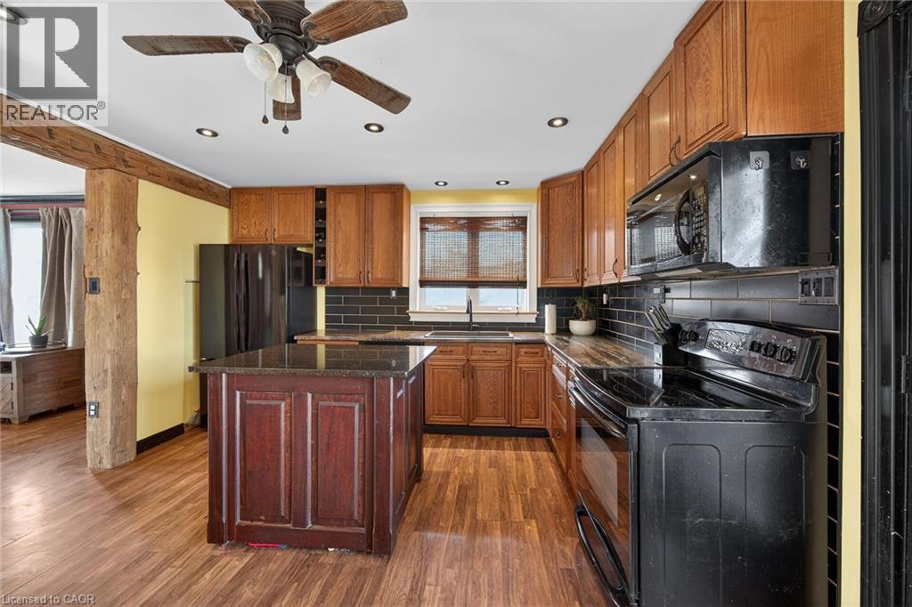 Kitchen with black appliances, dark wood-style floors, ceiling fan, backsplash, and wood finish cabinetry - 703 Dunn Avenue, Hamilton, ON - Indoor Photo Showing Kitchen