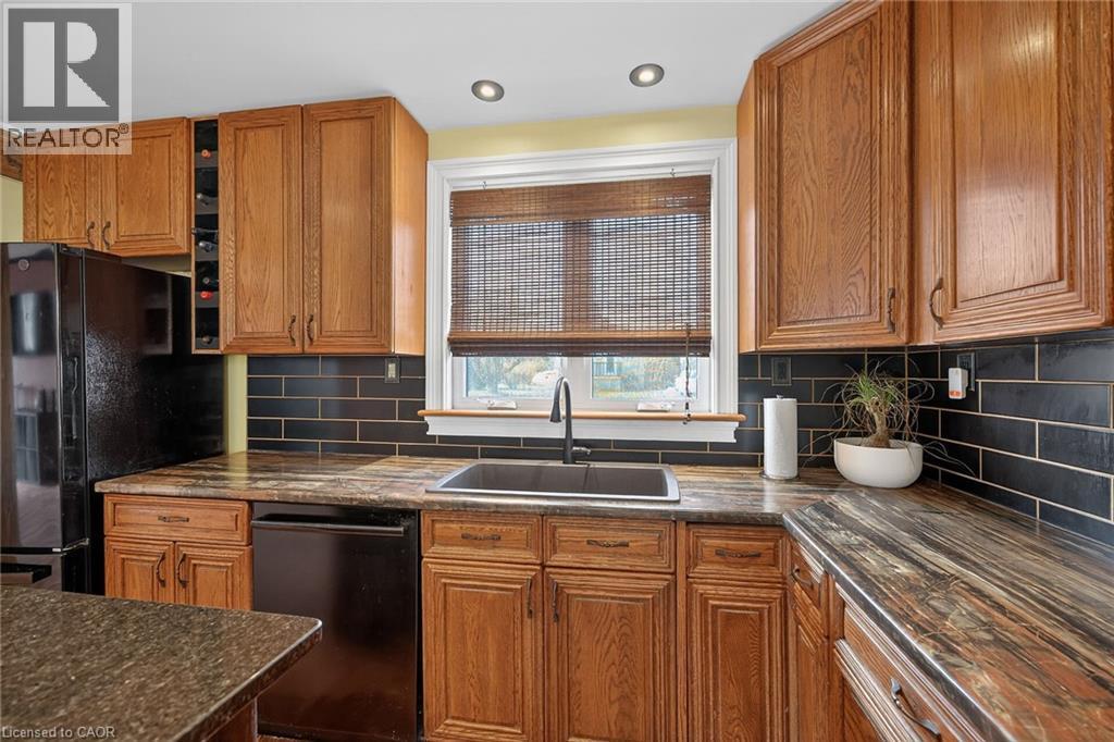 Kitchen with wood finish cabinets, black appliances, tasteful backsplash, recessed lighting, and dark stone counters - 703 Dunn Avenue, Hamilton, ON - Indoor Photo Showing Kitchen
