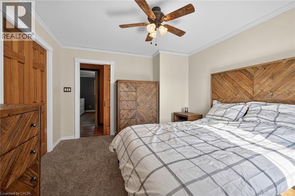 Bedroom with dark colored carpet, ornamental molding, and ceiling fan - 703 Dunn Avenue, Hamilton, ON - Indoor Photo Showing Bedroom