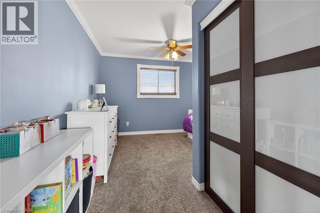 Bedroom featuring dark colored carpet, ceiling fan, and crown molding - 703 Dunn Avenue, Hamilton, ON - Indoor
