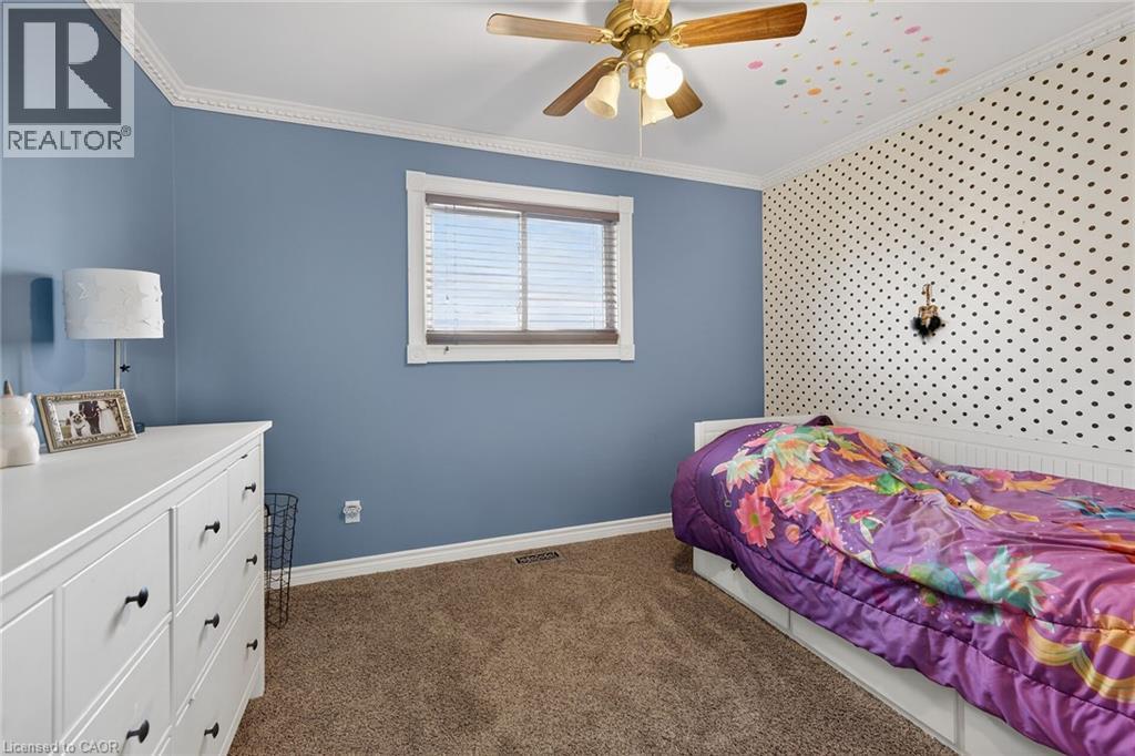 Bedroom featuring ornamental molding, dark colored carpet, and a ceiling fan - 703 Dunn Avenue, Hamilton, ON - Indoor Photo Showing Bedroom
