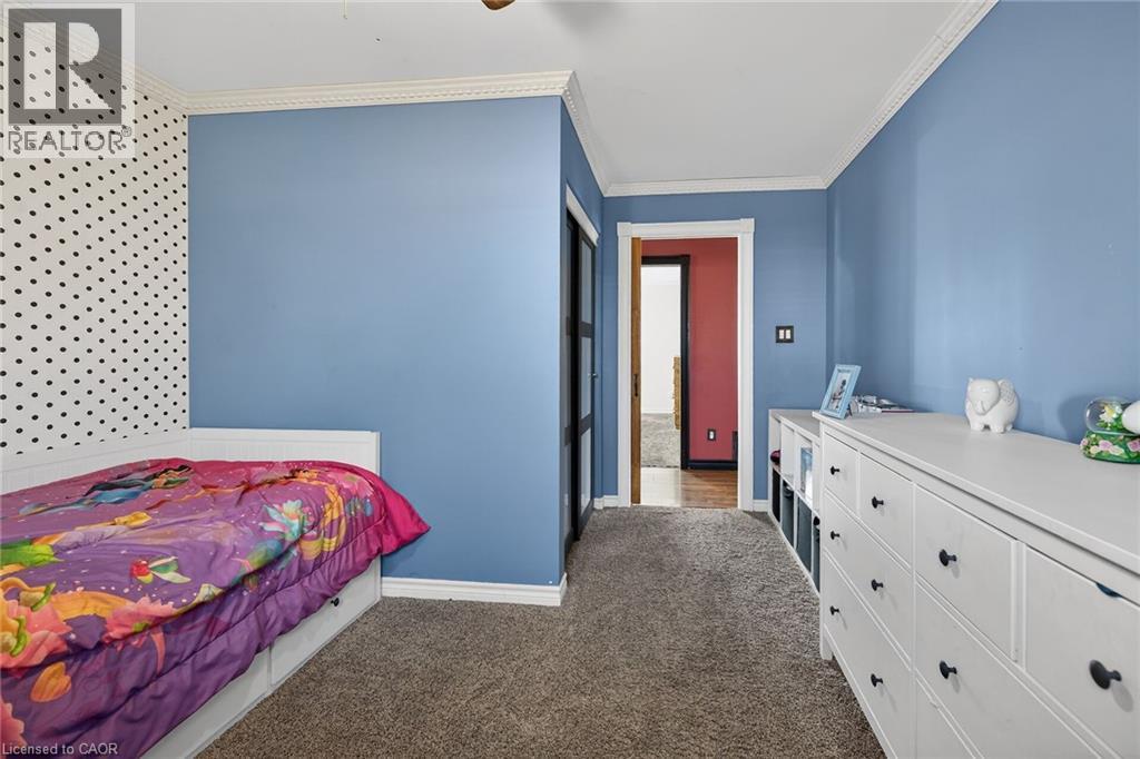 Bedroom with crown molding, dark carpet, and a ceiling fan - 703 Dunn Avenue, Hamilton, ON - Indoor Photo Showing Bedroom
