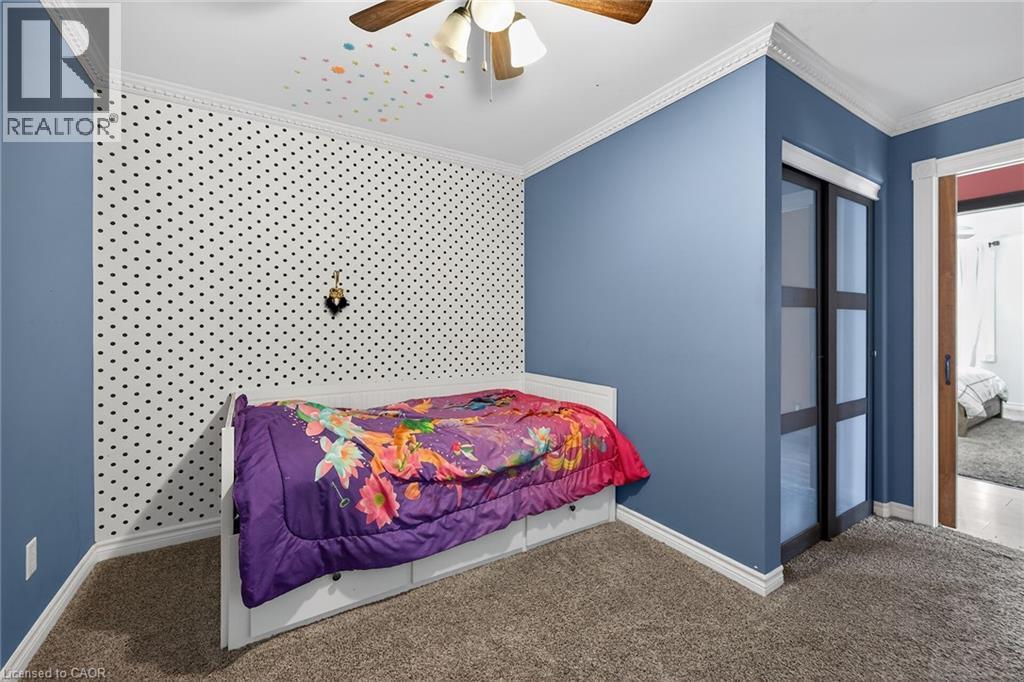 Carpeted bedroom featuring ornamental molding, ceiling fan, and a closet - 703 Dunn Avenue, Hamilton, ON - Indoor Photo Showing Bedroom