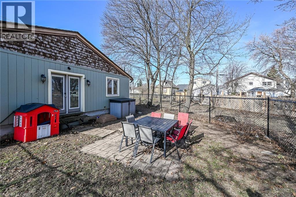 Fenced backyard featuring a patio, entry steps, outdoor dining area, a residential view, and french doors - 703 Dunn Avenue, Hamilton, ON - Outdoor