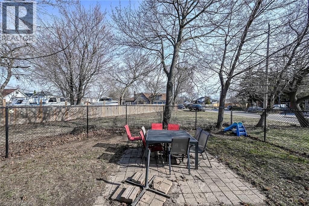 Fenced backyard with a patio area, outdoor dining space, and a residential view - 703 Dunn Avenue, Hamilton, ON - Outdoor