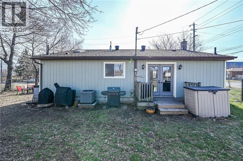 Back of property featuring french doors, roof with shingles, a deck, and a chimney - 703 Dunn Avenue, Hamilton, ON - Outdoor