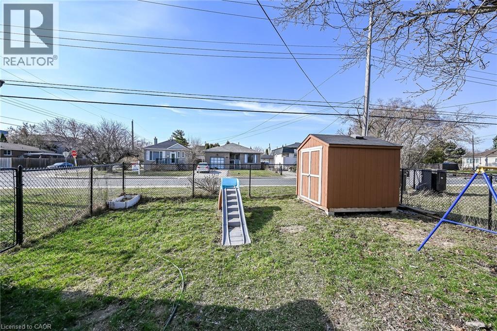 Fenced backyard featuring a residential view and a storage unit - 703 Dunn Avenue, Hamilton, ON - Outdoor