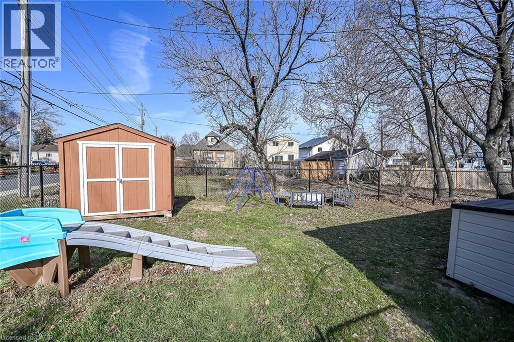 Fenced backyard with a storage unit and a residential view - 703 Dunn Avenue, Hamilton, ON - Outdoor