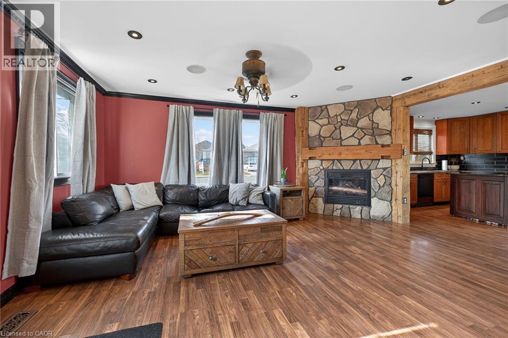 Living area with healthy amount of natural light, dark wood-style flooring, a fireplace, a ceiling fan, and recessed lighting - 703 Dunn Avenue, Hamilton, ON - Indoor Photo Showing Living Room With Fireplace