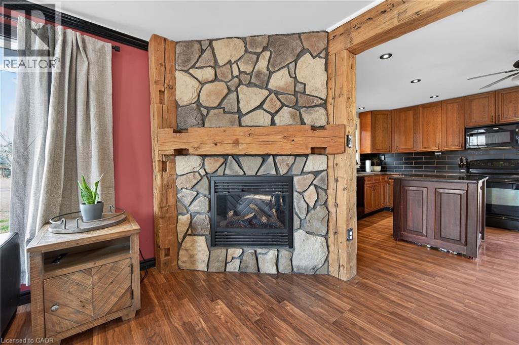 Kitchen featuring black appliances, tasteful backsplash, dark wood-type flooring, wood finish cabinets, and recessed lighting - 703 Dunn Avenue, Hamilton, ON - Indoor Photo Showing Living Room With Fireplace