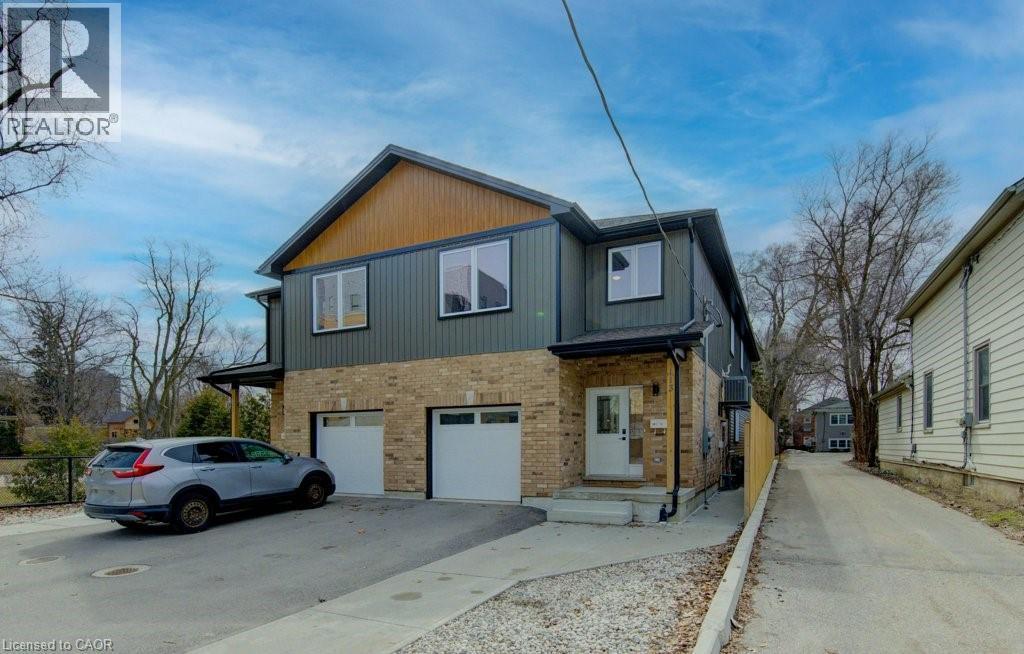View of front of property featuring brick siding, an attached garage, and driveway - 113 Walter Street, Kitchener, ON - Outdoor