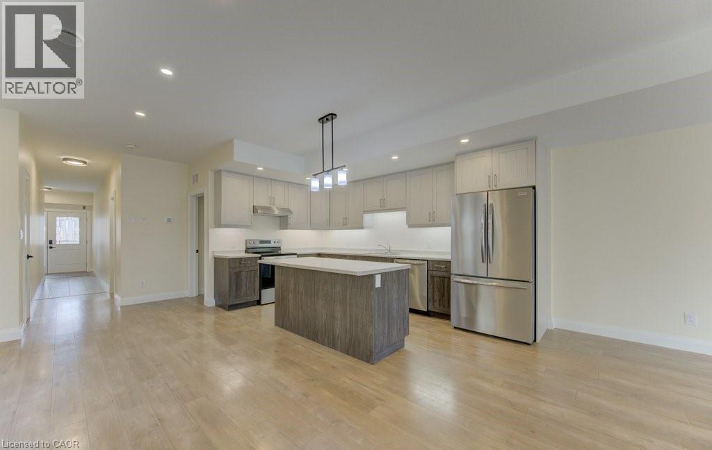 Kitchen with stainless steel appliances, light countertops, a center island, light wood finished floors, and dual tone cabinetry - 113 Walter Street, Kitchener, ON - Indoor Photo Showing Kitchen With Upgraded Kitchen