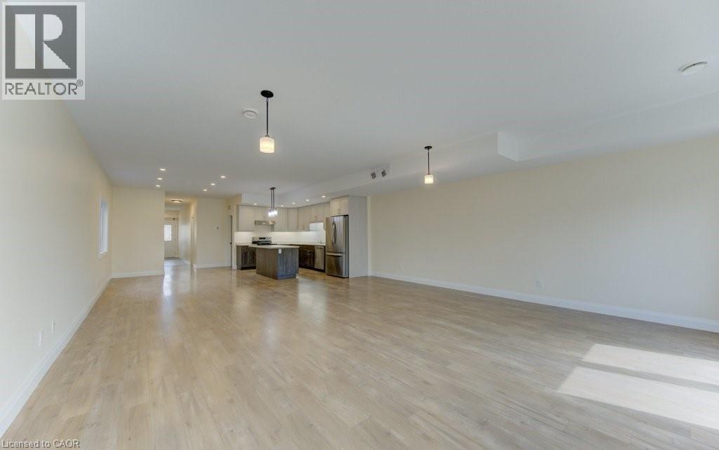Unfurnished living room featuring light wood-type flooring and recessed lighting - 113 Walter Street, Kitchener, ON - Indoor