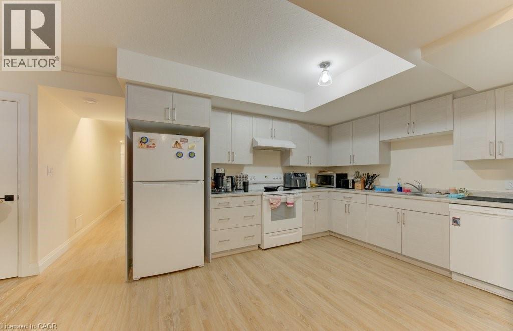 Kitchen featuring white appliances, light wood-style flooring, light countertops, and white cabinetry - 113 Walter Street, Kitchener, ON - Indoor Photo Showing Kitchen