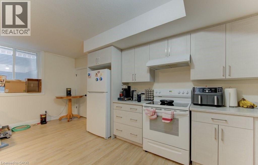 Kitchen featuring white appliances, light countertops, light wood-style floors, and white cabinetry - 113 Walter Street, Kitchener, ON - Indoor Photo Showing Kitchen