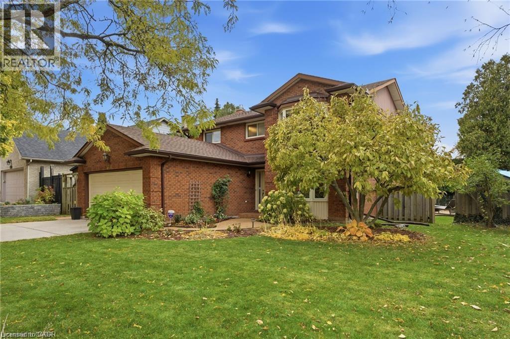 Traditional-style house with brick siding, a garage, a front yard, and driveway - 668 Tomahawk Crescent, Ancaster, ON - Outdoor