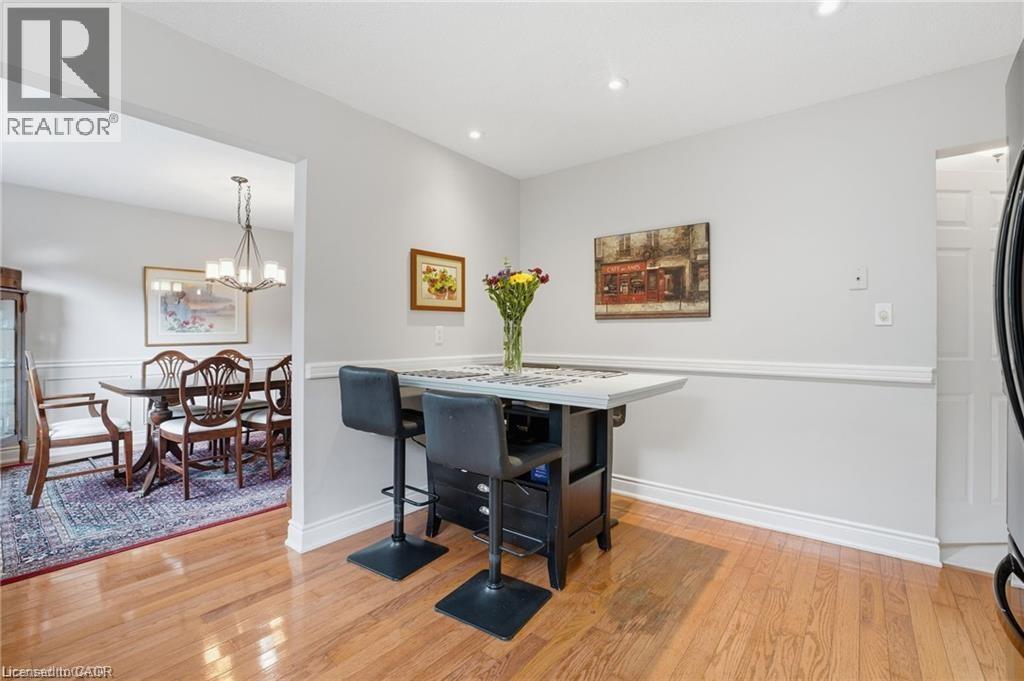 Dining area with light wood-style flooring and hanging lights - 668 Tomahawk Crescent, Ancaster, ON - Indoor