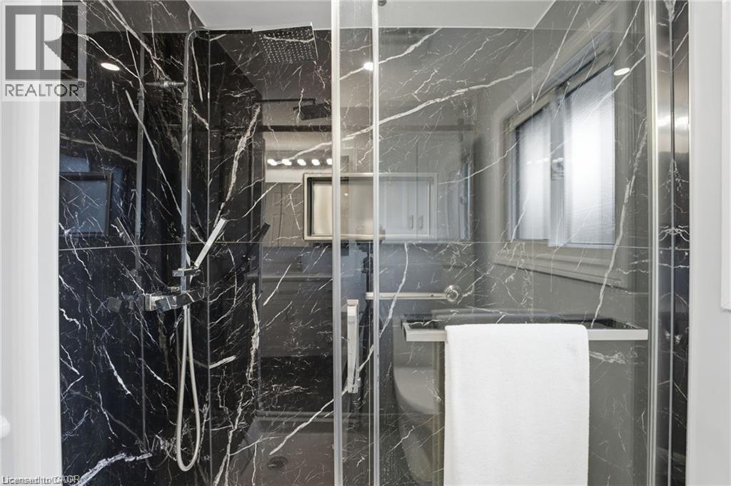 Full bath with a marble finish shower - 668 Tomahawk Crescent, Ancaster, ON - Indoor With Storage