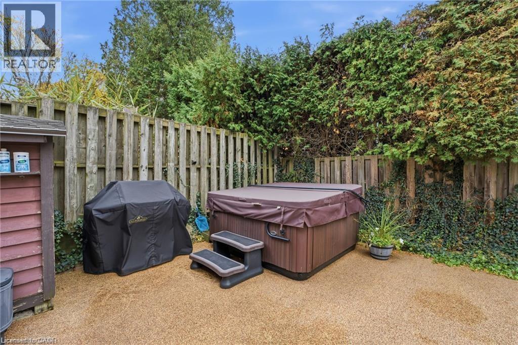 Fenced backyard with area for grilling and a hot tub - 668 Tomahawk Crescent, Ancaster, ON - Outdoor