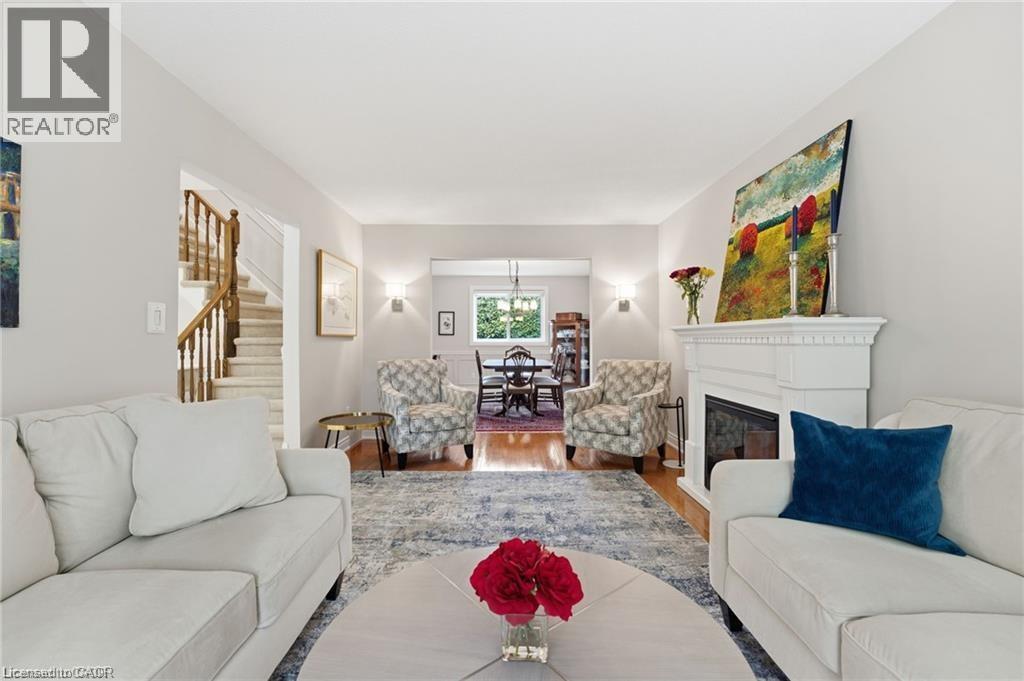 Living room with wood finished floors and a glass covered fireplace - 668 Tomahawk Crescent, Ancaster, ON - Indoor Photo Showing Living Room With Fireplace