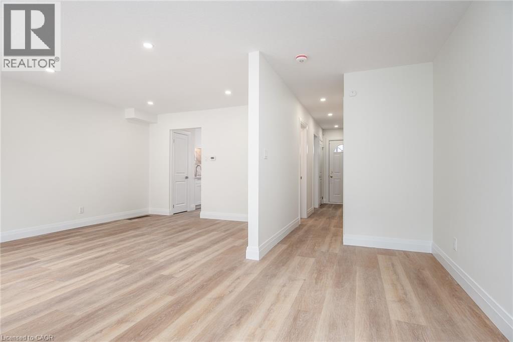 Empty room with light wood-style floors and recessed lighting - 27 Queenston Drive, Kitchener, ON - Indoor Photo Showing Other Room