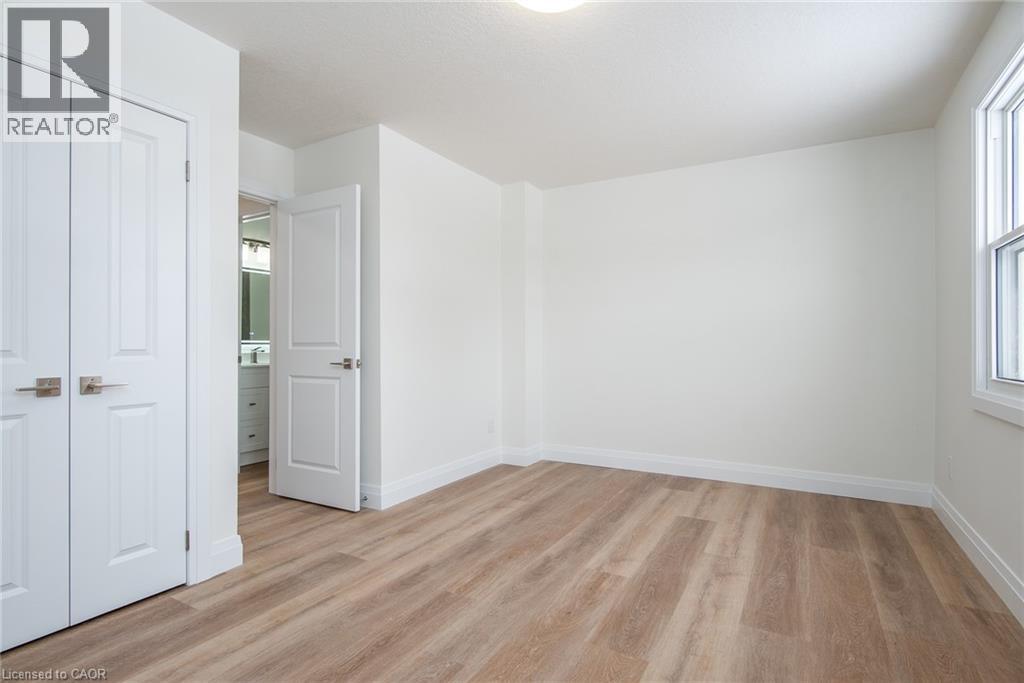 Unfurnished bedroom featuring light wood-style flooring and a closet - 27 Queenston Drive, Kitchener, ON - Indoor Photo Showing Other Room