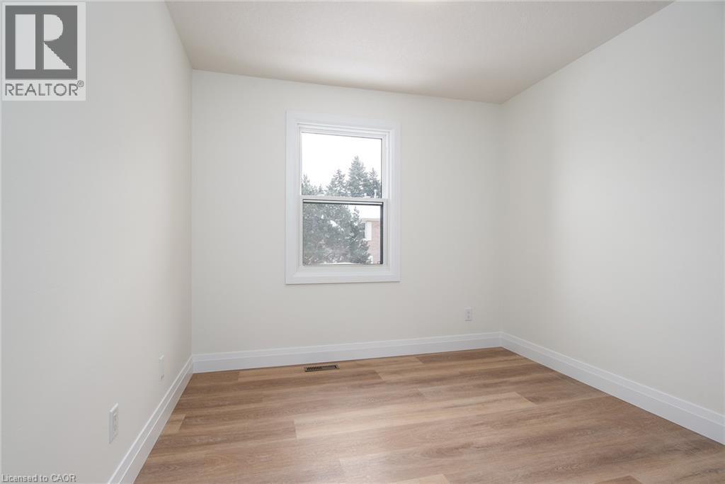 Unfurnished room with light wood-type flooring and baseboards - 27 Queenston Drive, Kitchener, ON - Indoor Photo Showing Other Room