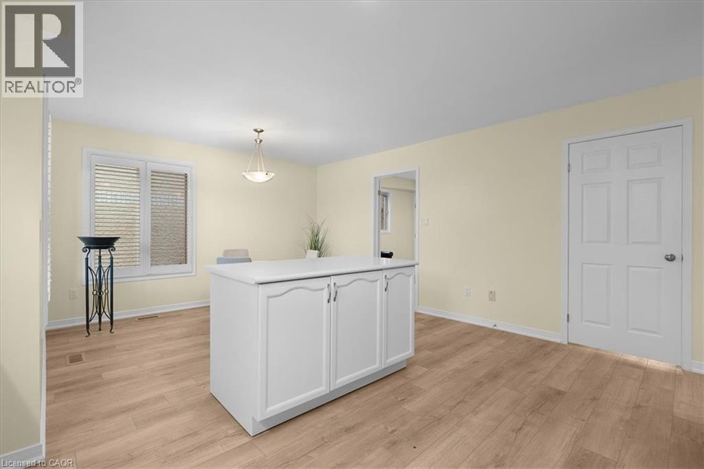 Kitchen with light countertops, white cabinets, light wood-type flooring, and decorative light fixtures - 90 Westlawn Drive, Hamilton, ON - Indoor Photo Showing Other Room