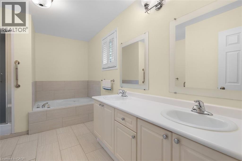 Bathroom featuring double vanity, tub, and light tile patterned floors - 90 Westlawn Drive, Hamilton, ON - Indoor Photo Showing Bathroom