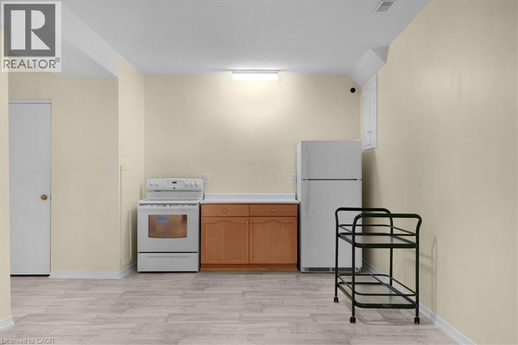 Kitchenette with white appliances, light countertops, light wood finished floors, and wood finish cabinets - 90 Westlawn Drive, Hamilton, ON - Indoor Photo Showing Kitchen