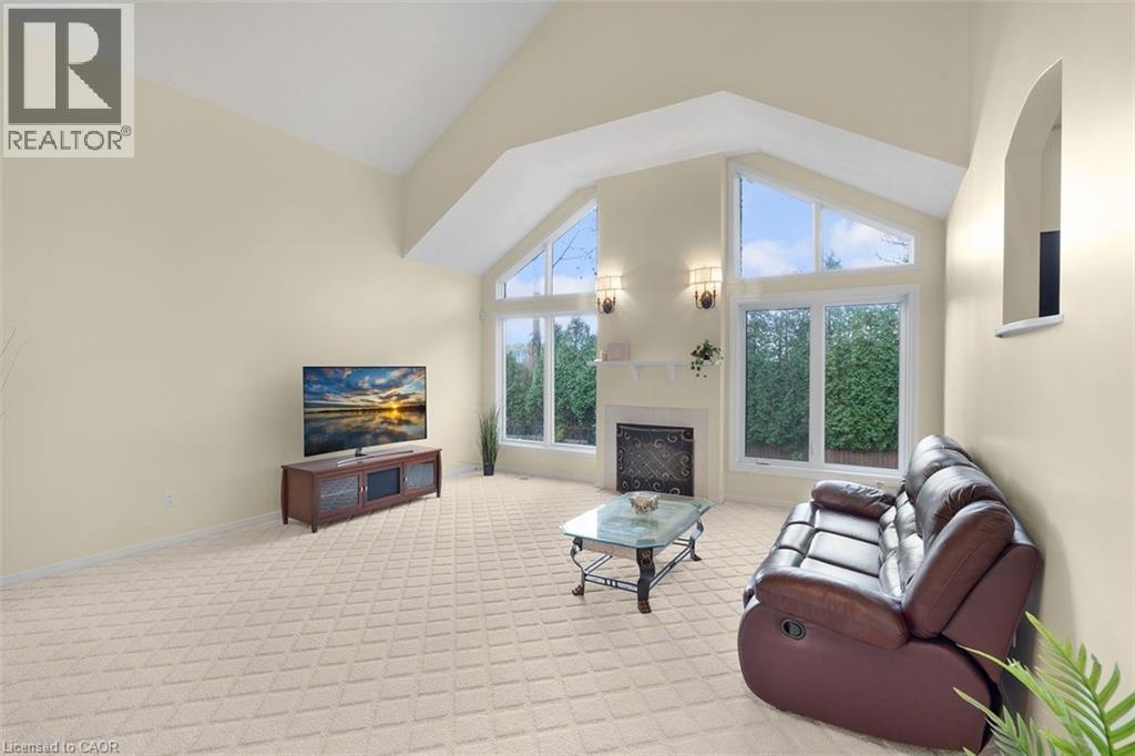 Living area featuring light carpet, lofted ceiling, and a fireplace - 90 Westlawn Drive, Hamilton, ON - Indoor