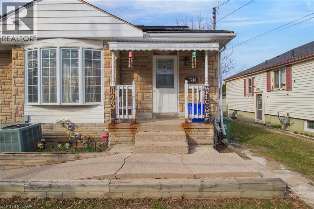 View of front of property featuring stone siding and a porch - 823 Queensdale Avenue E, Hamilton, ON - Outdoor