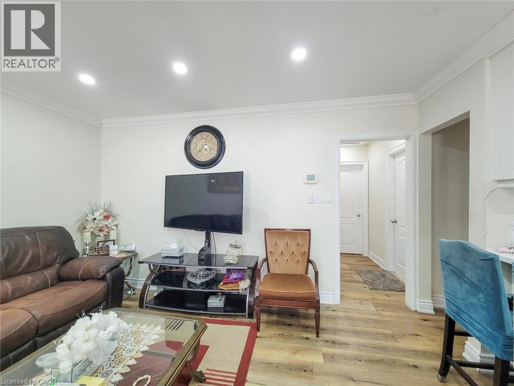 Living room with crown molding, light wood-style flooring, and recessed lighting - 823 Queensdale Avenue E, Hamilton, ON - Indoor Photo Showing Living Room