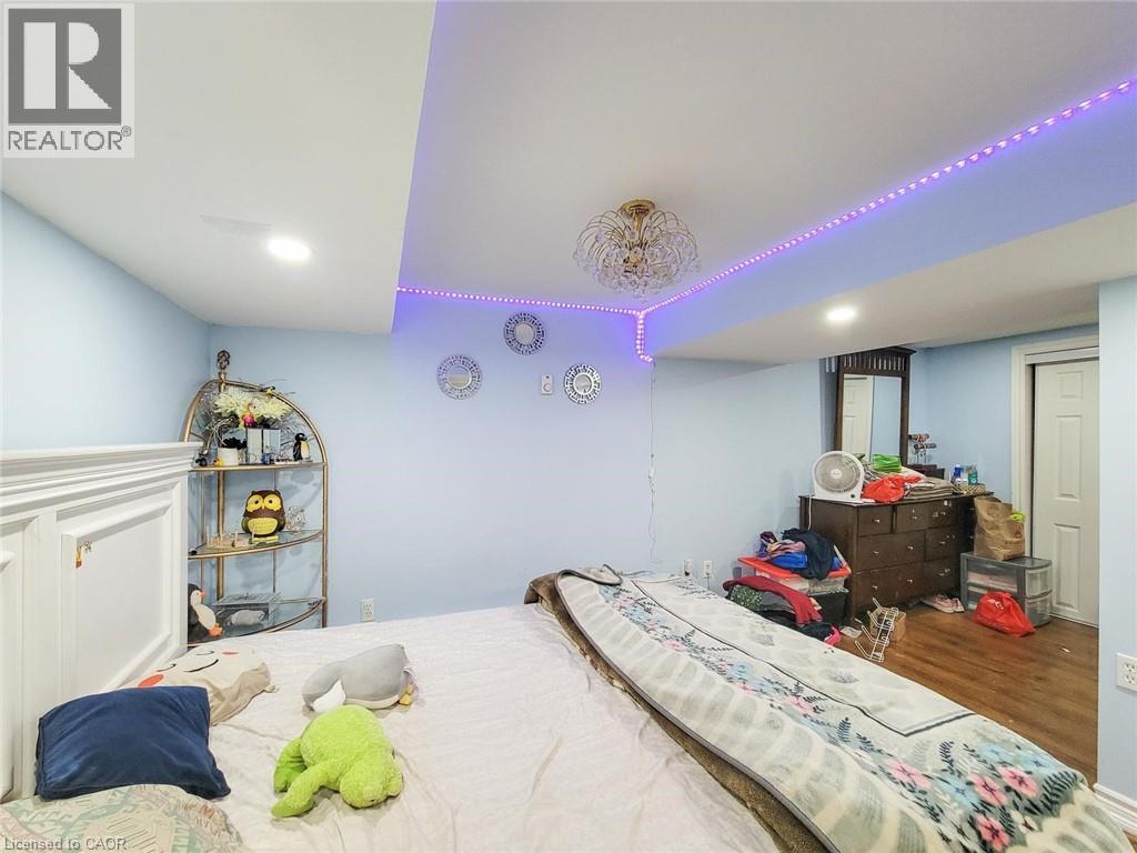 Bedroom featuring light blue walls and wood-finish flooring - 823 Queensdale Avenue E, Hamilton, ON - Indoor