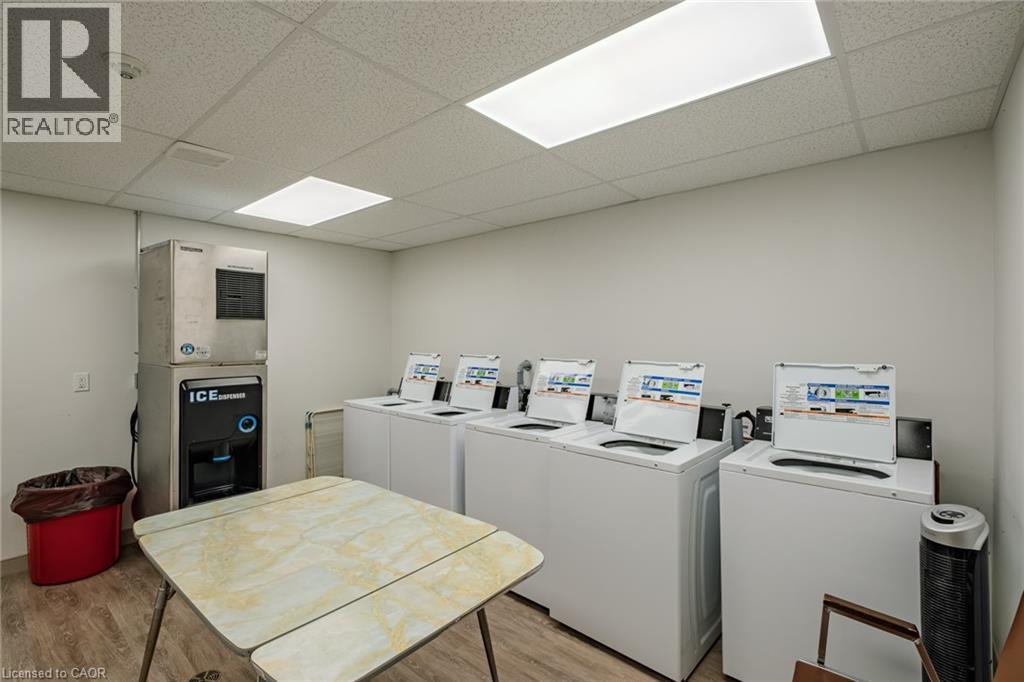 Community laundry with a drop ceiling and washing machine and dryer - 30 John Street, Port Dover, ON