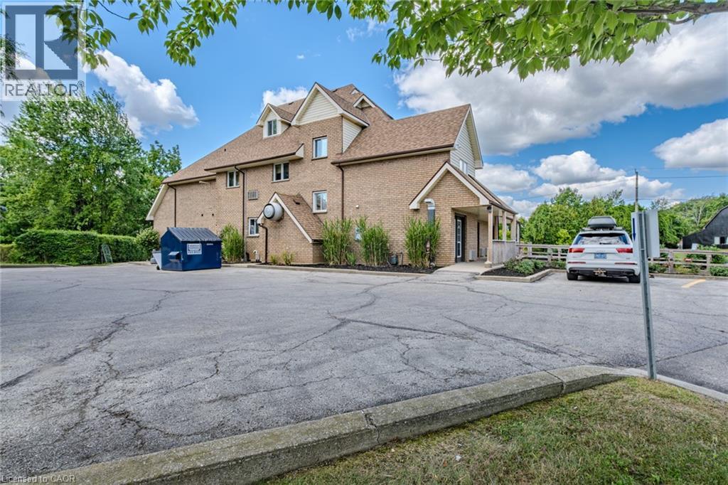 View of side of home with brick siding and uncovered parking - 30 John Street, Port Dover, ON