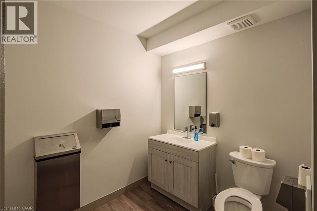 Half bathroom featuring vanity and dark wood-type flooring - 30 John Street, Port Dover, ON