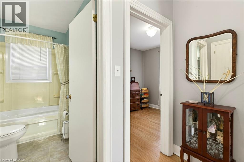 Bathroom featuring toilet and shower / bath combo with shower curtain - 944 Garth Street, Hamilton, ON - Indoor Photo Showing Bathroom