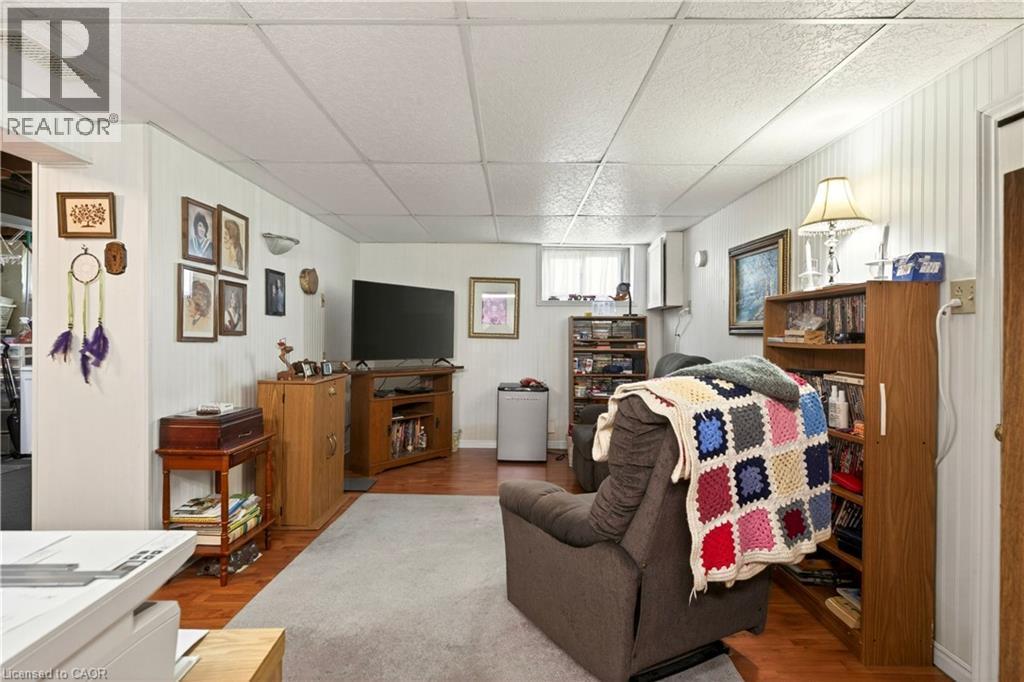 Living area with a paneled ceiling, wood walls, and wood finished floors - 944 Garth Street, Hamilton, ON - Indoor